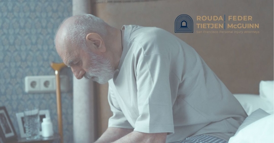 Sad elderly man sitting on his bed.